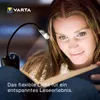 A woman is reading a book with a VARTA LED book light attached to it. Anteprima dell’immagine prodotto