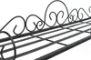 A close-up view of a black metal shelf with decorative scrollwork on the top edge. Anteprima dell’immagine prodotto