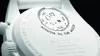 Close-up of the back of a white Swatch x Omega Bioceramic Moonswatch Mission To Moonphase Snoopy watch, showing the engraved details and a drawing of the moon with a paw print. Náhľad obrázku produktu