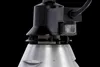 A close-up view of the top part of a heat lamp, showing the connection to the power cord and the ribbed metal shade. Produktbild-Vorschau