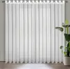 A white sheer curtain with eyelets hanging in front of a window. Produktbild-Vorschau