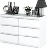 A white dresser with decorative items on top, including framed pictures, a vase of flowers, and a lamp. Produktbild-Vorschau