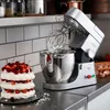 A kitchen scene with a stand mixer and a layered cake. Náhled obrázku produktu