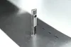 A silver and clear cylindrical product with a black label stands upright on a metallic surface. Náhľad obrázku produktu