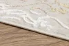 A close-up view of the edge of a rug on a wooden floor. Produktbild-Vorschau