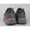 The back view of a pair of gray Puma sneakers with red accents. Produktbild-Vorschau