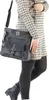 A person wearing a dress and tights, holding a black handbag. Náhled obrázku produktu