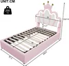 A pink upholstered bed with a crown-shaped headboard and LED lighting, shown with dimensions indicated. Produktbild-Vorschau