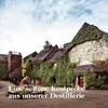 A historic distillery building covered in ivy, with text overlay. Produktbild-Vorschau