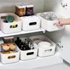 Storage bins organized on shelves inside a cabinet. Produktbild-Vorschau