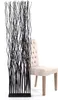 A black decorative screen stands in front of a beige upholstered chair against a white background. Náhled obrázku produktu