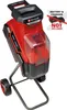 A red and black garden shredder on a stand with wheels, against a white background. A small inset graphic indicates that the battery and charger are not included. Podgląd zdjęcia produktu