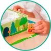 A child's hands are playing with a board game featuring bear characters and a forest scene. Náhled obrázku produktu