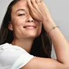 A woman is shown with her hand covering part of her face, wearing a bracelet with the letter M charm. Anteprima dell’immagine prodotto