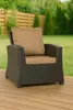 An outdoor chair with cushions on a wooden deck, with a garden and fence in the background. Produktbild-Vorschau