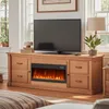 A living room setting with a TV stand featuring an electric fireplace, a television, and decorative items. Podgląd zdjęcia produktu