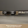 A black robot vacuum cleaner is shown under a piece of furniture, with a measurement indicating the clearance height. Produktbild-Vorschau