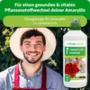 A man wearing a hat and apron is smiling, with a bottle of plant fertilizer next to him. Produktbild-Vorschau