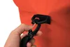 A hand is shown attaching a black carabiner clip to a black strap loop on an orange bag. Náhľad obrázku produktu