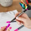 A person is using fabric markers to draw on a white t-shirt. Produktbild-Vorschau