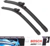 Two black windshield wiper blades are displayed diagonally on a white background, with a box of the product visible at the bottom. Produktbild-Vorschau