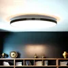 A modern ceiling light fixture is shown mounted on a ceiling above a shelf filled with books and decorative items. Produktbild-Vorschau