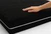 A hand touching a black mattress. Produktbild-Vorschau