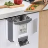 A kitchen scene with a foldable trash can attached to a cabinet door, with vegetables being chopped on a cutting board above it. Náhľad obrázku produktu