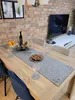 A dining table set for a festive occasion with a table runner, wine bottle, candles, oranges, and cookies. Produktbild-Vorschau