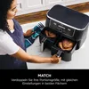 A woman is using a dual-zone air fryer with two chickens inside. Produktbild-Vorschau