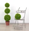 A decorative plant stand with a potted plant and a tiered plant stand with a potted plant. Produktbild-Vorschau