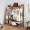 A bamboo clothing rack with clothes and storage boxes. Voir les images du produit
