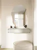 A modern vanity setup with a floating shelf, an abstract mirror, and a pouf. Náhľad obrázku produktu