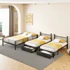 Three metal beds with yellow and white bedding are arranged in a room with a large arched window and a painting on the wall. Anteprima dell’immagine prodotto