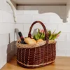 A picnic basket filled with bread, a bottle of wine, and flowers sits on a wooden counter against a tiled wall. Náhľad obrázku produktu