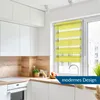 A modern kitchen with white cabinets, wooden accents, and a yellow roller blind. Produktbild-Vorschau