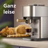 A cat sleeping next to a coffee machine while it brews coffee. Voir les images du produit