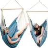 Two women relaxing in blue and white striped hanging chairs against a white background. Anteprima dell’immagine prodotto