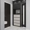 A modern entryway with a dark wood door and a built-in storage unit with drawers and shelves. Produktbild-Vorschau