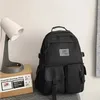 A black backpack is displayed next to a lamp and a storage rack box. Náhľad obrázku produktu