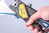 A hand holding a JOKARI automatic wire stripper tool, with a blue wire inserted. Anteprima dell’immagine prodotto