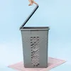 A hand is shown closing the lid of a gray laundry basket. Anteprima dell’immagine prodotto