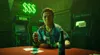 A woman sits at a table with cards and a bottle of beer in front of two arcade machines and a neon sign. Produktbild-Vorschau
