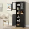 A black storage cabinet with multiple doors and shelves is shown in a room setting, next to a dining table and chair. Náhľad obrázku produktu
