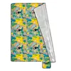 A picnic blanket with a tropical pattern is shown laid out, partially unfolded. Produktbild-Vorschau