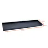 A dark gray rectangular metal tray with rounded feet, shown from a diagonal angle against a white background. Dimensions are indicated with orange lines and text. Voir les images du produit