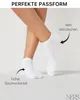 A close-up shot of a person's legs and feet wearing white ankle socks, with arrows and text highlighting product features. Produktbild-Vorschau