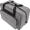 A gray sewing machine storage bag with black handles and zippers, shown from a slightly elevated side angle. Náhľad obrázku produktu