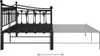Side view of a black metal bed frame with a mattress that extends outwards, indicated by a faded representation and an arrow graphic. Produktbild-Vorschau