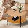 A person sitting on a couch next to a round coffee table with a cup of coffee and a vase of tulips. Produktbild-Vorschau